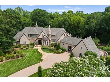Expansive estate home with beautiful landscaping, stone accents, and a circular driveway, perfect for luxurious living at 8500 Longview Club Dr, Waxhaw, NC 28173