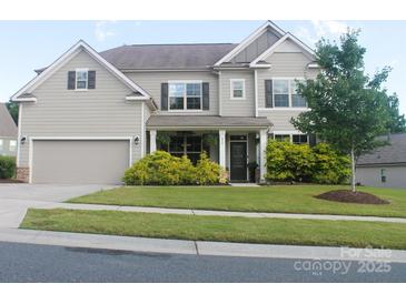 Charming two-story home with a well-maintained lawn and inviting front porch at 858 Oak Manor Se Dr, Concord, NC 28025