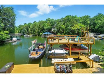 Picturesque waterfront view featuring a private boat dock with boat lifts and a lounging area at 10043 Tepa Pl, Tega Cay, SC 29708