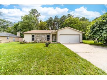 Charming single-story home features a stone facade, attached garage and a well-manicured lawn at 10951 Fox Mill Ln, Charlotte, NC 28277