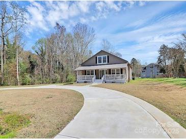 Charming home features a welcoming front porch and a long driveway at 12300 Caldwell Rd, Charlotte, NC 28213