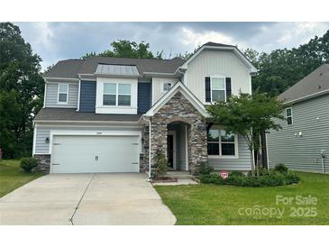 Charming two-story home featuring a stone entryway, attached garage, and well-manicured front lawn with landscaping at 14505 Rhodes Hall Dr, Charlotte, NC 28273