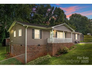 Charming home featuring a brick foundation, inviting front porch, and lush green lawn at 146 Duff St, Gastonia, NC 29715