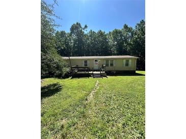 Ranch home featuring a small front porch, manicured lawn, and lush landscaping at 194 Wild Plum Ln, Blacksburg, SC 29702