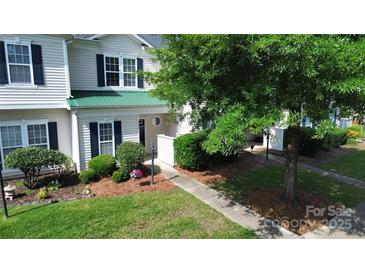 Charming townhome featuring a well-manicured lawn and tasteful landscaping, complete with a welcoming front walkway at 4151 Town Center Rd, Harrisburg, NC 28075