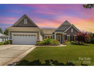 Charming single-story home with well-manicured lawn, flowerbeds, and attached two-car garage at 4208 Rosy Billed Ct # 30, Fort Mill, SC 29707