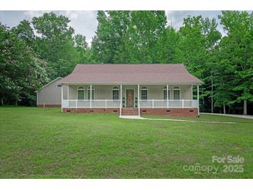 Charming home featuring a covered porch with white railings, a brick foundation, and lush green lawn at 441 Vermilion Dr, York, SC 29745
