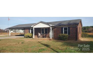 Charming brick home with a quaint front porch and carport offers curb appeal at 711 Burtonwood Ln, Lincolnton, NC 28092