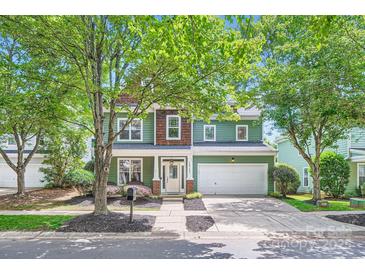 Charming two-story home with green siding, wood accents, and a well-maintained front yard at 18732 Coachmans Trce, Cornelius, NC 28031