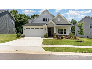 Charming single-Gathering home featuring a two-car garage, manicured lawn, and welcoming front porch at 218 Tetcott St, Mooresville, NC 28115