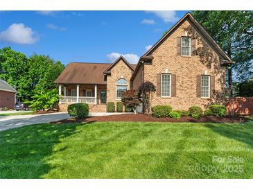 Charming brick home with lush front lawn and manicured landscaping at 3831 Riceland Pl, Charlotte, NC 28216
