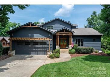 Charming home with a gray exterior, complemented by wood accents, stone details, and a well-manicured lawn at 7221 High Point Ct, Charlotte, NC 28278