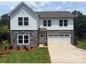 Charming two-story home with stone accents, white siding, attached garage, and a well-manicured lawn at 10339 Lakeshore Dr # 85, Lancaster, SC 29720