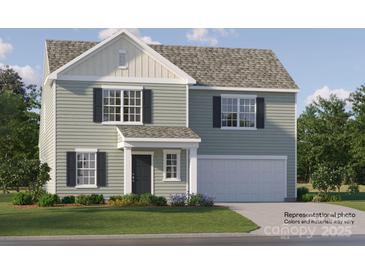Charming two-story home with sage siding, black shutters, and a two-car garage offers a welcoming curb appeal at 1904 Old Ormand Ln, Bessemer City, NC 28016