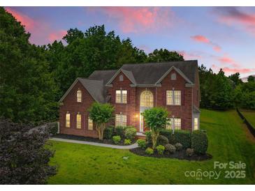 Stunning brick home featuring manicured landscaping, mature trees, and a classic architectural design at 3213 Strawberry Rd, Matthews, NC 28104