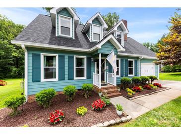 Charming two-story home featuring a well-maintained lawn, colorful flowerbeds, and inviting front porch at 328 Pamela St, Gastonia, NC 28054