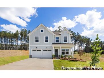 Charming two-story home featuring a two-car garage, a well-manicured lawn, and a welcoming front porch at 36140 Greg Norman Dr # 1003, Lancaster, SC 29720