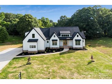 Beautiful modern farmhouse with black accents, a manicured lawn, and a private wooded backdrop at 5015 Lancaster Hwy, Monroe, NC 28112