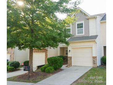 Charming two-story townhome featuring a one-car garage, manicured lawn, and inviting front entrance at 14411 Glendon Hall Ln, Charlotte, NC 28262