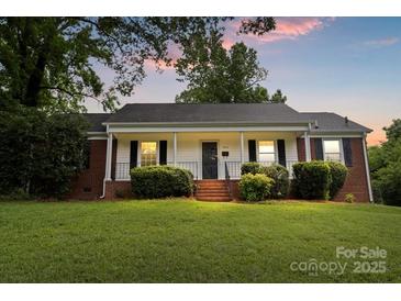 Charming home featuring a well-manicured lawn and front porch, set against a lovely sunset sky at 1512 Anthony Dr, Gastonia, NC 28052