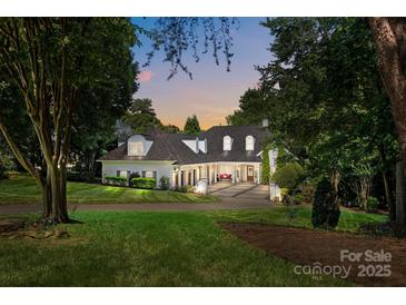 Beautiful brick home featuring mature trees, manicured lawn, and inviting front entrance at 19506 Mary Ardrey Cir, Cornelius, NC 28031