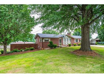 Charming brick home with well-maintained lawn and mature trees, offering great curb appeal at 2836 20Th Street Ne Ln, Hickory, NC 28601
