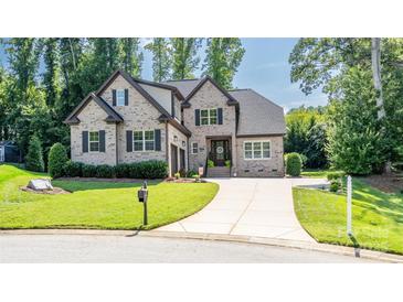Charming brick two-story home with manicured lawn and mature trees, featuring a long driveway and welcoming front porch at 4017 Halyard Dr, Denver, NC 28037