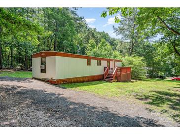Charming single-story home with gravel driveway and a small deck at 5239 Lineberger Rd, Stanley, NC 28164