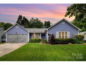 Charming one-story home with manicured lawn, beautiful landscaping and periwinkle blue siding at 5711 Lambrook Ct, Charlotte, NC 28269
