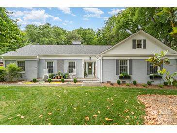 Charming single-story home featuring a welcoming front porch, well-maintained lawn, and manicured landscaping at 827 Ashwyn Dr, Charlotte, NC 28211