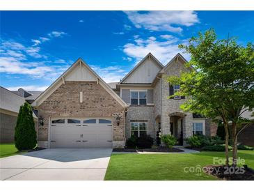 Charming two-story home featuring a blend of brick and stone, a well-manicured lawn, and a two-car garage at 11313 Limehurst Pl, Charlotte, NC 28278