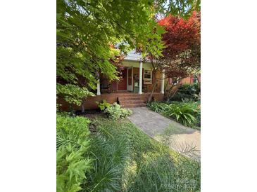 Charming brick home with a well-maintained front yard and inviting front porch with rocking chairs at 19924 Floral Ln, Cornelius, NC 28031