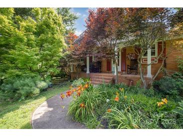 Charming brick home with a welcoming front porch, rocking chairs, and colorful landscaping at 19924 Floral Ln, Cornelius, NC 28031