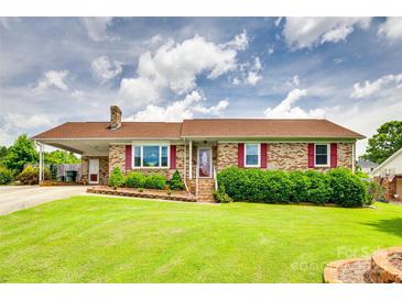 Charming brick home featuring a well-manicured lawn, red shutters, and a covered carport at 3903 Graywood Dr, Gastonia, NC 28052
