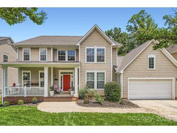 Charming two-story home with a red front door, inviting porch, attached garage, and well manicured landscaping at 5832 Lagrande Dr, Charlotte, NC 28269