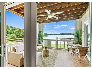 Inviting covered outdoor patio with wicker furniture offers scenic lake views and relaxing ambiance at 860 Jetton St # 59, Davidson, NC 28036