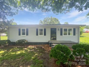 Charming single-story home with white siding, black shutters and front-yard landscaping at 908 Mccollough St, Statesville, NC 28677