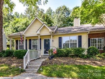 Charming yellow home with a cozy front porch and manicured landscaping at 9337 Four Mile Creek Rd # 101, Charlotte, NC 28277