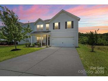 Charming two-story home featuring vinyl siding, an attached two-car garage, and a well-manicured front yard at 10111 Snowbell Ct, Charlotte, NC 28215