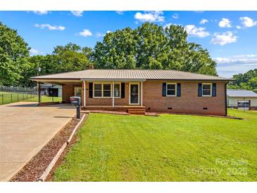 Charming single-story brick home featuring a metal roof, well-maintained lawn, and a convenient carport at 124 Island Park Ln, Statesville, NC 28625