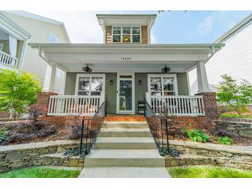 Charming two-story home featuring a covered porch, landscaped front yard, and inviting curb appeal at 14533 Holly Springs Dr, Huntersville, NC 28078