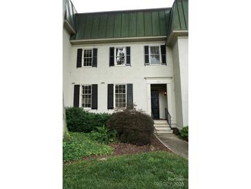 Charming exterior featuring a symmetrical facade, black shutters, and lush landscaping at 153 Perrin Pl, Charlotte, NC 28207