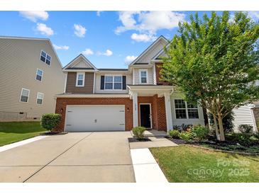 Charming two-story home featuring a brick facade, two-car garage, and well-maintained landscaping at 1569 Shannon Falls Dr, Fort Mill, SC 29715