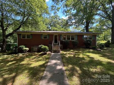 Charming brick ranch home with mature trees and a well-manicured lawn in a serene setting at 211 S Slack St, Albemarle, NC 28001