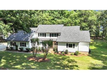 Charming two-story home with white siding, a gray roof, a well-manicured lawn, and mature trees at 316 Wade Hampton Dr, Matthews, NC 28104