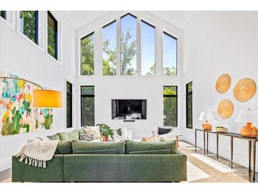 Bright living room with soaring ceilings, oversized windows, and comfortable seating with a modern aesthetic at 3304 Mar Vista Cir, Charlotte, NC 28209