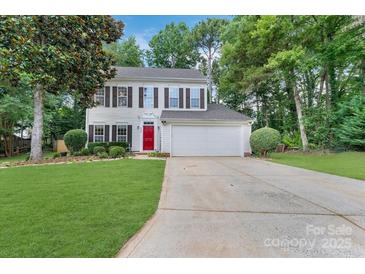 Charming two-story home with a well-manicured lawn, red door, and attached two car garage at 4000 Garfield Ct, Waxhaw, NC 28173