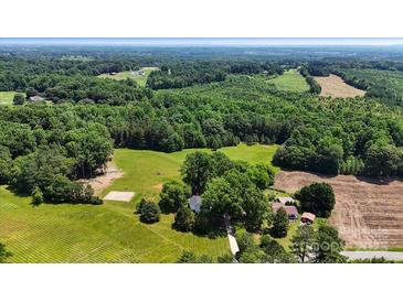 Expansive aerial view of a property featuring lush green fields and dense woodlands at 5740 Crouse Rd, Crouse, NC 28033