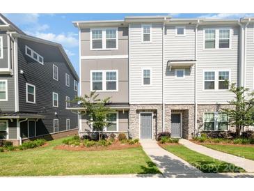Charming townhome with stone accents, manicured lawn and a welcoming walkway to the front door at 7012 Bryce Ave, Charlotte, NC 28217