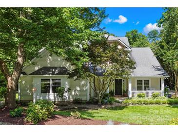 Charming home with a well-manicured lawn and inviting front porch nestled among mature trees at 833 Lemond Ln, Denver, NC 28037
